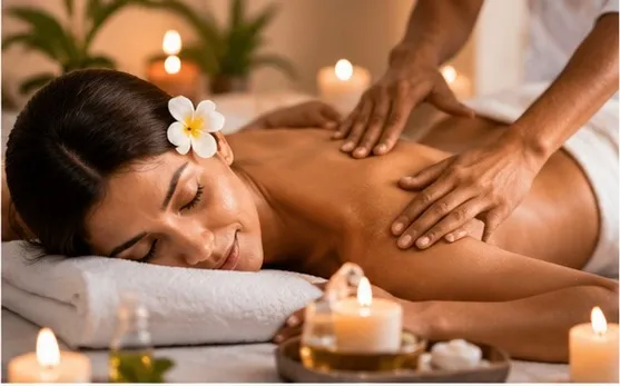 A therapist giving a back massage by candlelight in a spa treatment room